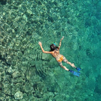 Aerial drone view of woman snorkeling at Phi Phi Island, Thailand